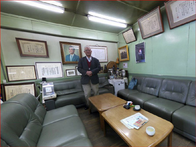 HPFhito43・多くの表彰状に囲まれた光合金製作所会長井上一郎氏 パノラマ写真風土記